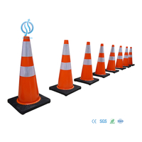 Extendable orange and black traffic cone on road
